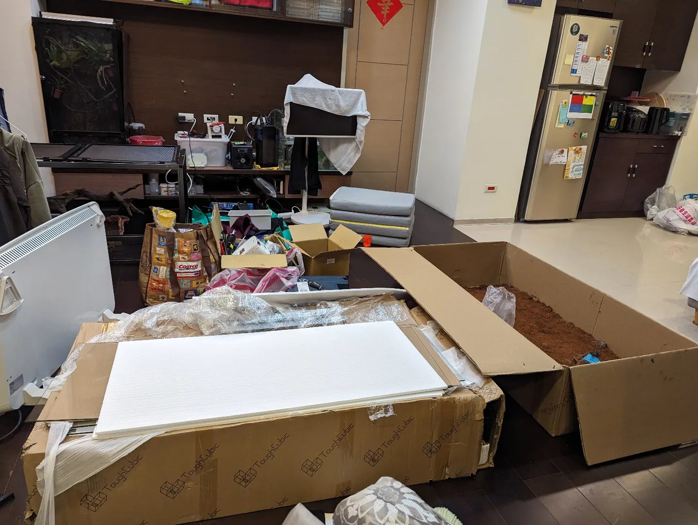 客廳地上拆開的 Tough Cubic 紙箱與保麗龍板, 旁邊一個大紙箱裡裝著拌好的球蟒缸混合土